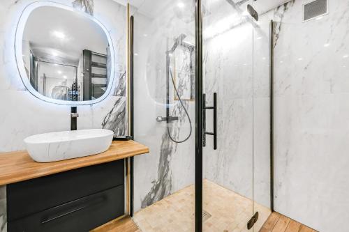 un bagno con lavandino e specchio di La Rêverie - Love Room Paris - Jacuzzi Pro a Parigi