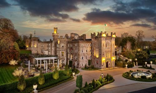 an old castle is lit up at dusk at Cabra Castle Hotel in Kingscourt