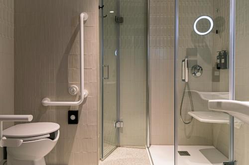 a bathroom with a shower and a toilet and a sink at Living Place Hotel in Villanova
