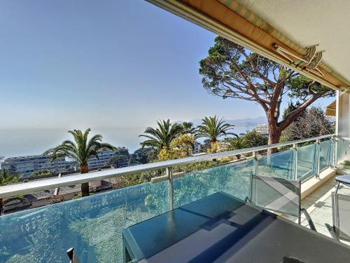 d'un balcon avec vue sur l'océan et les palmiers. dans l'établissement Superbe 3 pièces vue mer 323L MUNAR, à Cannes