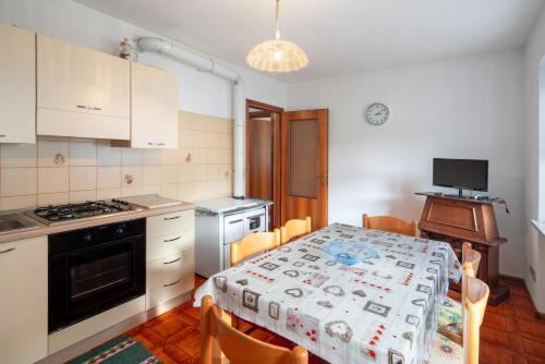 a kitchen with a table and a kitchen with a stove at Appartamenti Minotto Falcade in Falcade