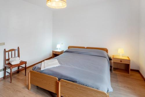 a bedroom with a bed and a chair and a lamp at Appartamenti Minotto Falcade in Falcade