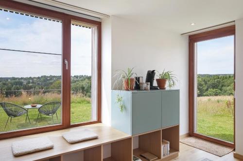 a room with a large window and a table and chairs at Le pré de Régine et Joseph in Malmedy