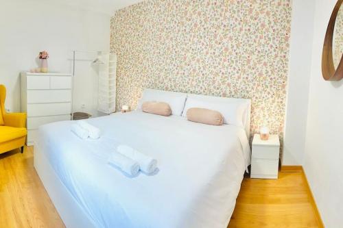 Un dormitorio con una cama blanca con dos toallas encima. en Ático Villa Isabella, en Granada