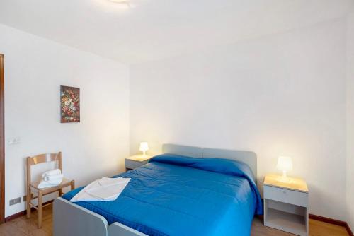 a bedroom with a blue bed and two lamps at Appartamenti Minotto Falcade in Falcade