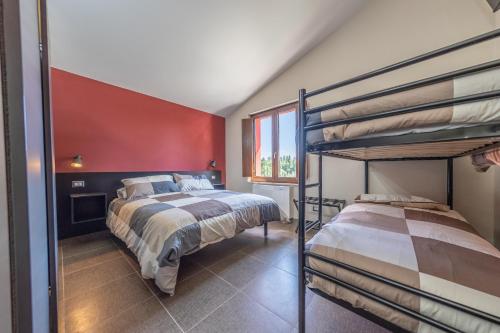 a bedroom with two bunk beds and a red wall at SANBARTO LA CASA DEL BORGO in Cassano Irpino