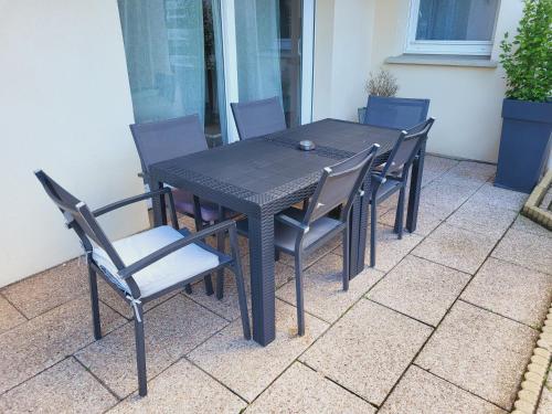 a black table and chairs on a patio at La marine D'opale in Ambleteuse