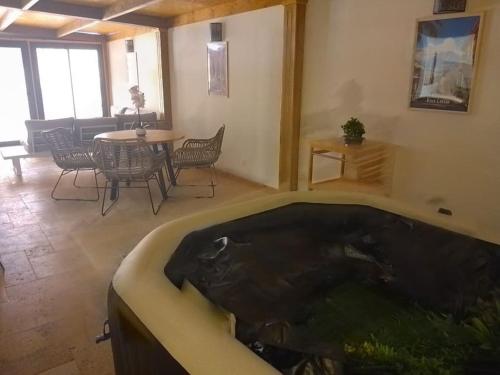 a large bath tub in a room with a table and chairs at Villa de l'Océan in Saint-Pierre