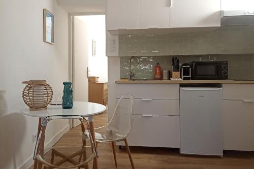 - une cuisine avec une table, une table et des chaises dans l'établissement Pied à terre au Panier - Superbe vue sur le port, à Marseille