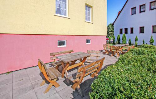 a group of wooden tables and chairs next to a building at Ferienwohnung Peenemünde in Peenemünde