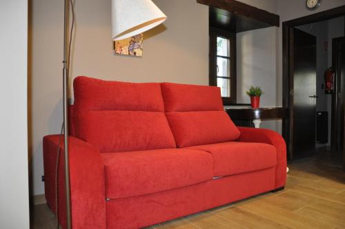 a red couch sitting in a living room at Casa Pacho Apartamentos Rurales in Luarca