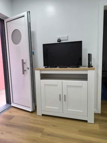 a white cabinet with a television on top of it at Alojamento Emílio T1 in Gafanha da Encarnação