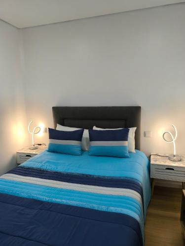 a bedroom with a blue bed with two night stands at Alojamento Emílio T1 in Gafanha da Encarnação
