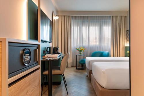 a hotel room with a large bed and a table at Living Place Hotel in Villanova