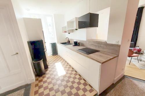 - une cuisine avec des placards blancs et un sol en damier dans l'établissement La suite 21, 73 m2 de charme, Centre ville, à Dijon