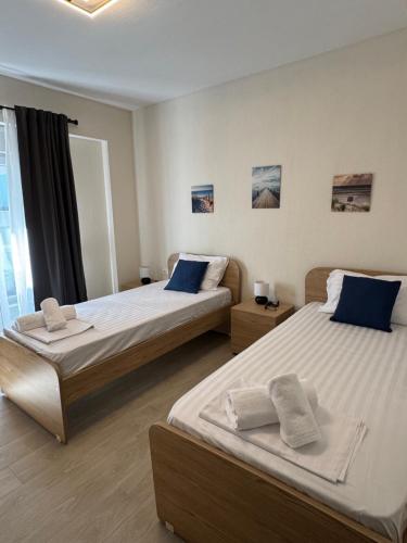 una camera da letto con due letti con cuscini blu di Luxury Villa Irinis a Nikiti