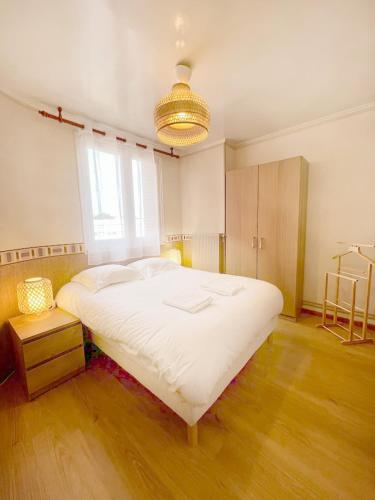 un grand lit blanc dans une chambre avec une fenêtre dans l'établissement L'Amicale : 80 m², 6 Prs, 3 Ch, Centre ville, à Dijon