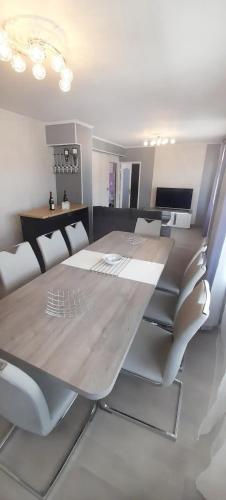 une salle à manger avec une grande table et des chaises en bois dans l'établissement L'Amicale : 80 m², 6 Prs, 3 Ch, Centre ville, à Dijon