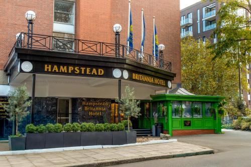 a building with a green storefront with flags on it at Hampstead Britannia in London