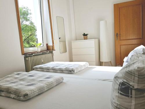 two twin beds in a bedroom with a window at Ferienwohnung Oberhausen Sterkrade nahe Westfield CentrO in Oberhausen