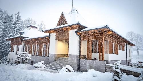un edificio coperto di neve di fronte di Villa Bellini Borszék a Borsec