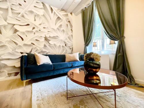 un salon avec un canapé bleu et une table dans l'établissement L'Ecrin: Appartement de charme en cœur historique, à Dijon