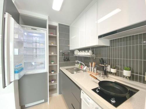 a kitchen with a sink and a refrigerator at House of Hyuni in Busan