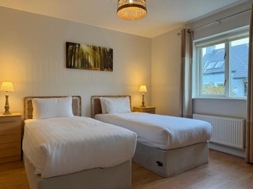 a bedroom with two beds and a window at Doolin Village Lodges in Doolin