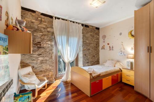 a bedroom with a bed and a stone wall at Regalate Paz in Estallo