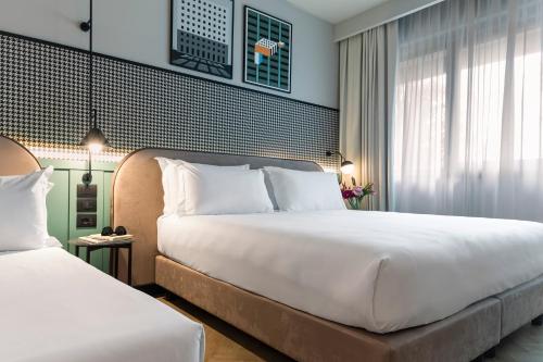 a hotel room with two beds and a window at Living Place Hotel in Villanova