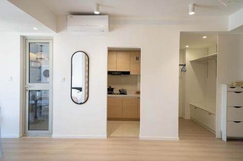 a white room with a mirror and a kitchen at Shanghai Yi Du B&B - Near Nanjing West Road commercial district, 350 walk from the Natural History Museum subway in Shanghai