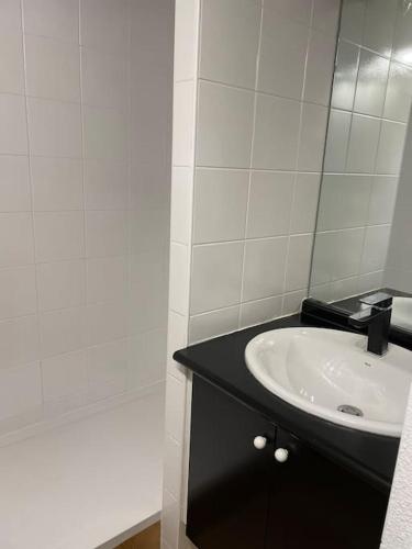 une salle de bain avec un lavabo et un miroir dans l'établissement St Lary centre 4 à 6 personnes piscine vue montagne, à Saint-Lary-Soulan