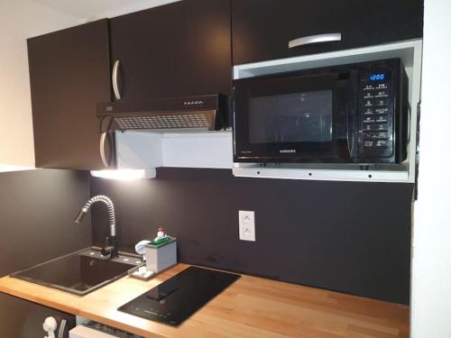 La cuisine est équipée d'un four micro-ondes et d'un évier. dans l'établissement St Lary centre 4 à 6 personnes piscine vue montagne, à Saint-Lary-Soulan