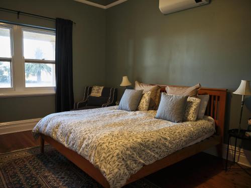 a bedroom with a bed with pillows and a window at Forgo tten Paddock in Maitland