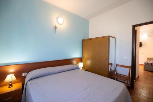 a bedroom with a bed with a cross on the wall at Villaggio Camping Fiorina in Capo Vaticano