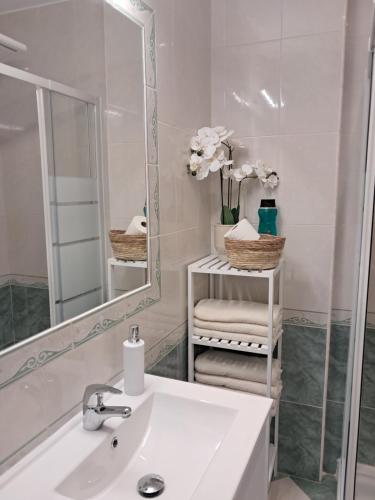 a white bathroom with a sink and a mirror at PLAYA PASEO MARITIMo in Sanlúcar de Barrameda