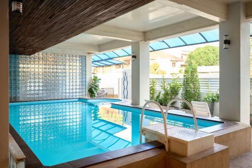 a swimming pool in a house with a patio and a house at Thapae60 Mini Hotel in Chiang Mai
