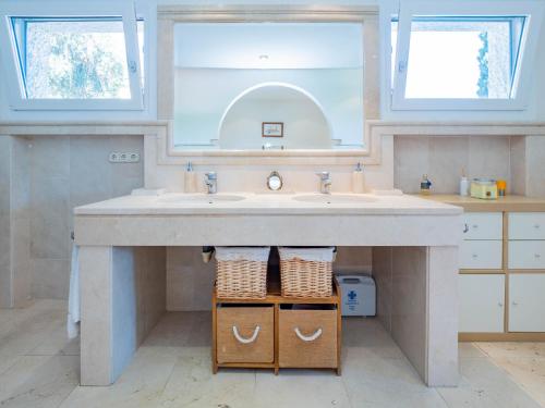 a bathroom with a sink and two mirrors at Cubo's Villa Las Capuchinas in Torremolinos