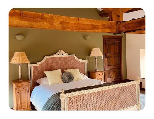 a bedroom with a large bed and two night stands at The Coach House in Berriew