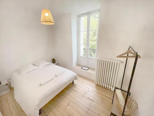 une chambre blanche avec un lit et une fenêtre dans l'établissement Le Philibert : 50m², 4 Prs, 2 Ch : proche gare, à Dijon