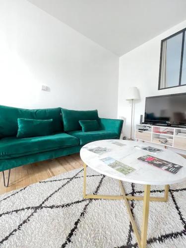 - un salon avec un canapé vert et une table basse dans l'établissement Le Philibert : 50m², 4 Prs, 2 Ch : proche gare, à Dijon