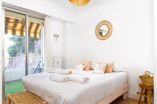 deux lits dans une chambre blanche avec une fenêtre dans l'établissement 5mn Monaco - Cosy 2 pièces - Balcon vue mer - CL, à Beausoleil