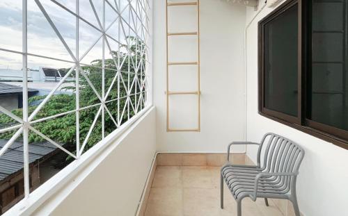 a room with a chair and a large window at Sleeping Shine de Budget พักได้ 2-3 ท่าน in Satun
