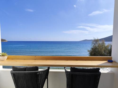 a view of the ocean from a balcony with two chairs at Ammos Sifnos Village in Platis Yialos Sifnos