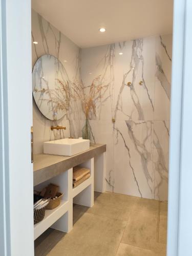 a bathroom with a sink and a mirror at Ammos Sifnos Village in Platis Yialos Sifnos