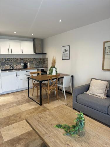 Il dispose d'une cuisine et d'un salon avec une table et un canapé. dans l'établissement Appartement proche de la mer, à Fréjus