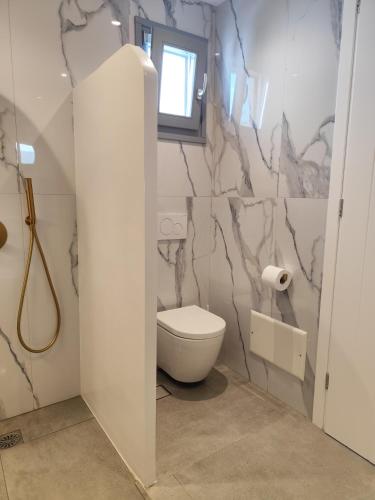 a bathroom with a toilet and a window at Ammos Sifnos Village in Platis Yialos Sifnos