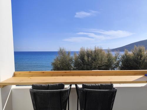 a view of the ocean from a balcony with two chairs at Ammos Sifnos Village in Platis Yialos Sifnos