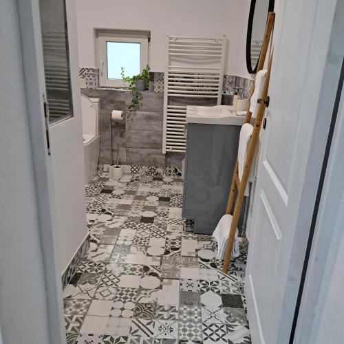 a bathroom with a black and white tile floor at Apartament rustic, curte aproape de Castelul Bran in Bran