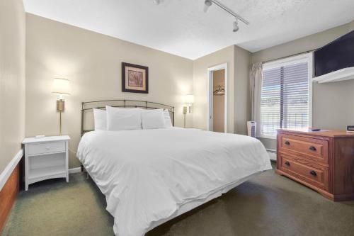 a bedroom with a large white bed and a window at 110 Pointes North Inn in Charlevoix